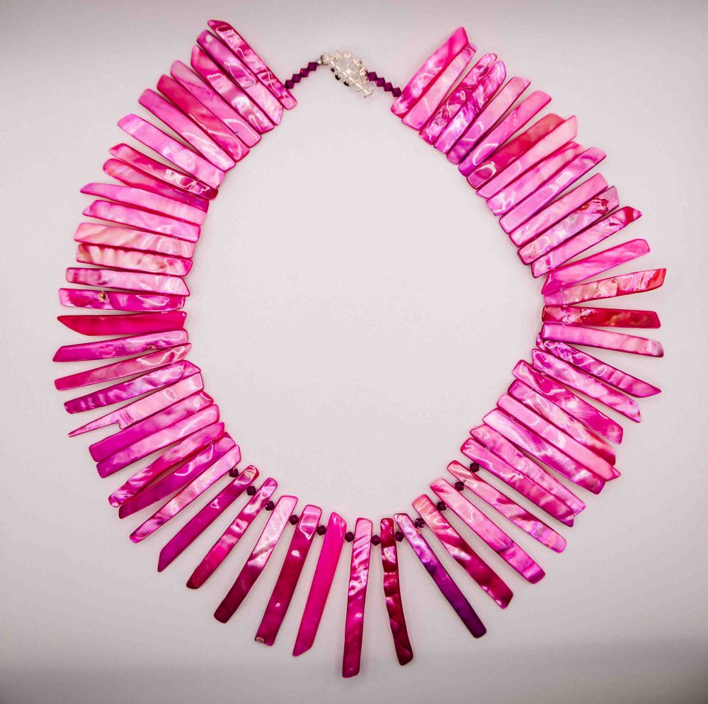 Pink necklace with a gradient effect on a light gray background