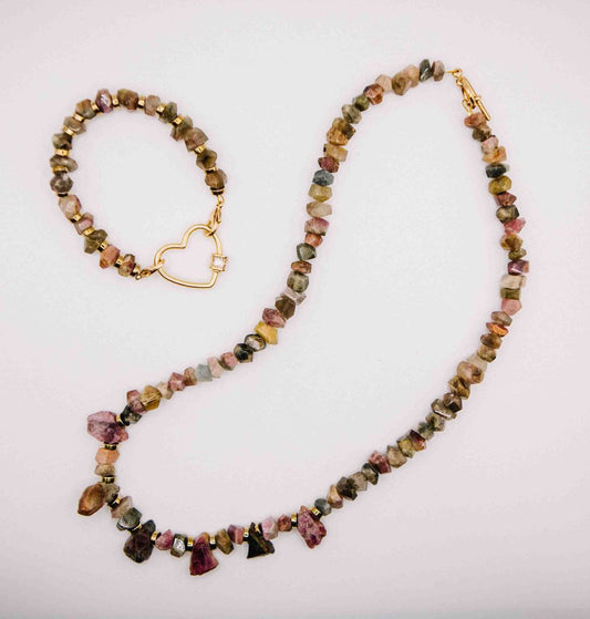 Necklace and bracelet set with multicolored beads on a light pink background