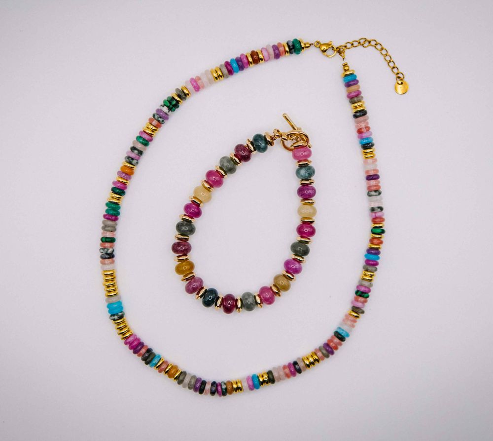 Multicolored beaded necklace and bracelet set on a light gray background