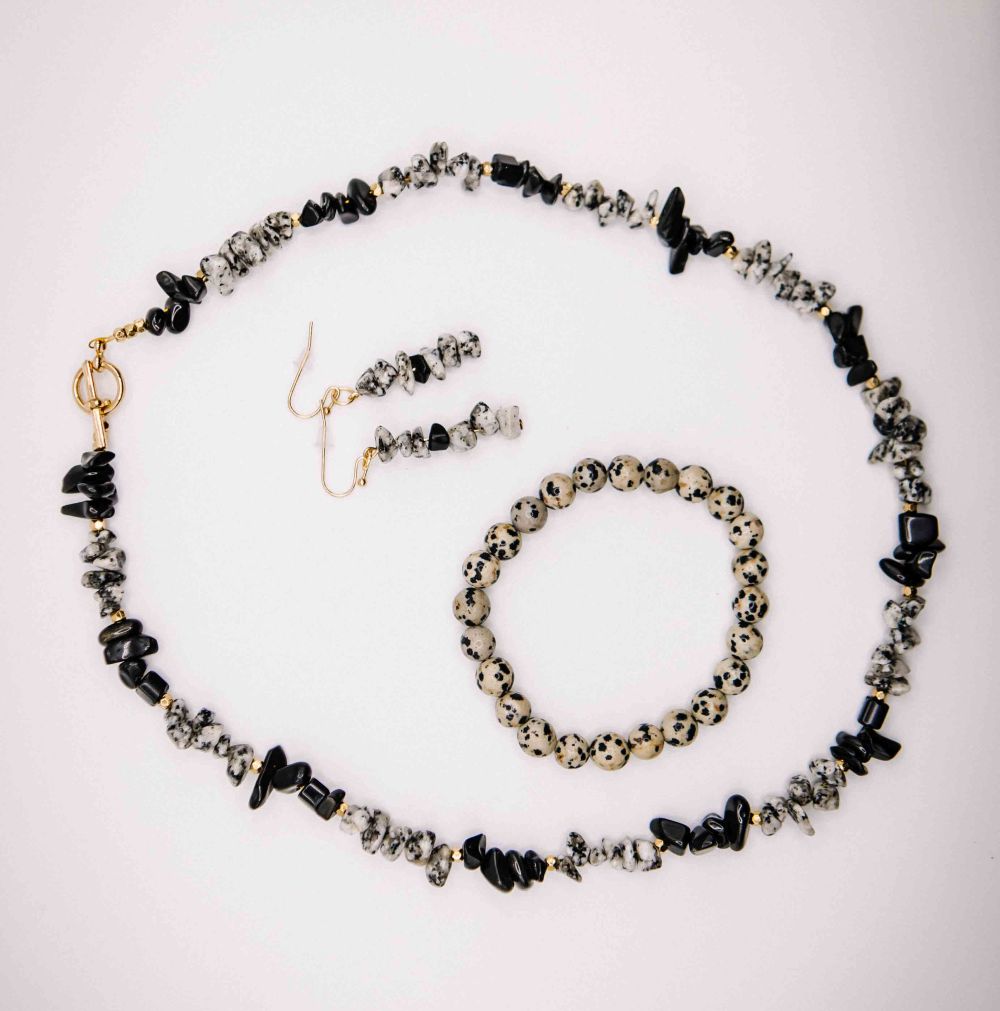 Necklace, bracelet, and earrings with black and gray stones on a white background