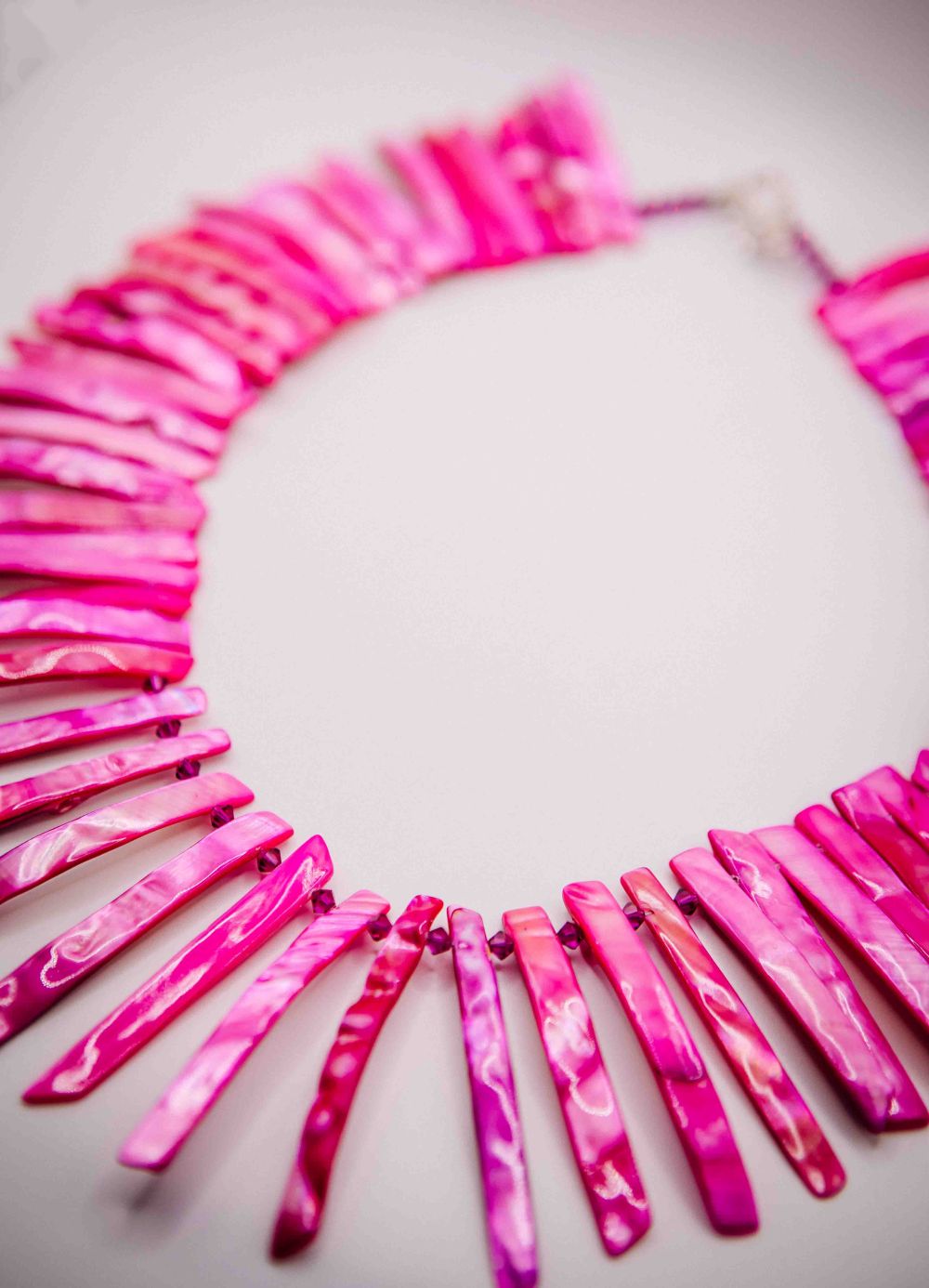 Necklace with pink marbled stones on a light gray background