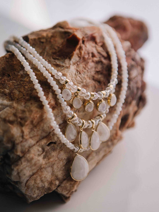 A necklace with gold accents on a textured stone surface